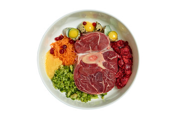 Natural raw dog food in bowl isolated  on white background. BARF diet Raw meat, eggs, vegetables.