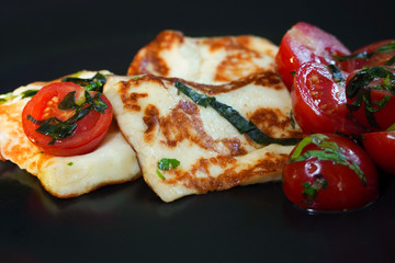 Grilled halloumi cheese with cherry tomatoes and basil