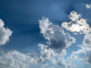 Dark blue sky with rays of sunlight through clouds