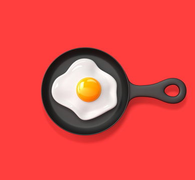Fried egg in a frying pan isolated on red background