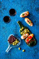Red wine and snacks set on wine bottle plate top view