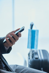 man using his smartphone, and surgical mask