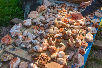 colorful mineral stones from the tunnels of a deep mercury mine are laid out for sale on the surface of an old door