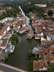 Fototapeta na wymiar Aerial view of old town hall in Bamberg, Bavaria, Germany. House above river Main. Вridge, boats ancient historic half-timbered buildings with orange roofs. Beautiful cityscape.
