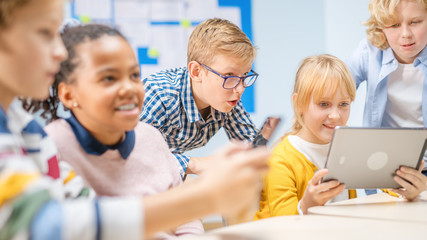 Elementary School Computer Science Class: Children Use Digital Tablet Computers and Smartphones with Augmented Reality Software, They’re Excited, Full of Wonder. Children in STEM, Playing and Learning