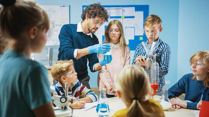 Elementary School Science Classroom: Enthusiastic Teacher Explains Chemistry to Diverse Group of...
