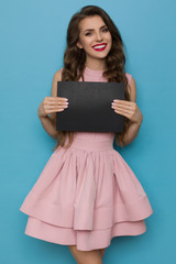 Cheerful Beautiful Young Woman In Elegant Pink Cocktail Dress Is Holding Black Card