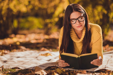 Photo of focused girl tourist hide city center countryside lying checkered plaid blanket fall forest lawn grass read book wear yellow color sweater jumper