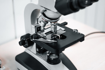 close-up of a microscope in a veterinary laboratory. medical research virus center in grayscale....