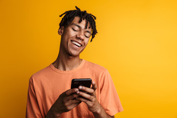 Fototapeta premium Young happy african man with cellphone isolated