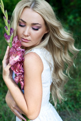 Beautiful young woman with flower wreath and long hair. Blonde. Hair care. Summer. Bride