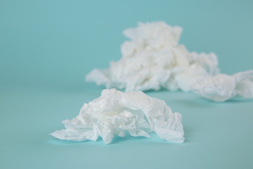 Used paper tissues on light blue background, closeup