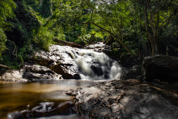 The waterfall in the big forest flows beautifully.