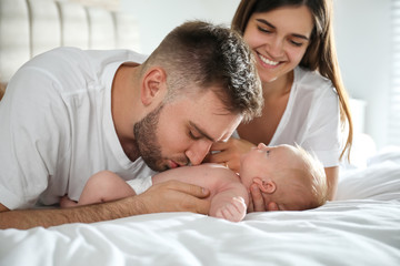 Fototapeta na wymiar Happy couple with their newborn baby at home