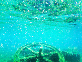 Rest of the old cableway wheel on the seabed in front of the beach of Terranera, Tuscany, Italy.