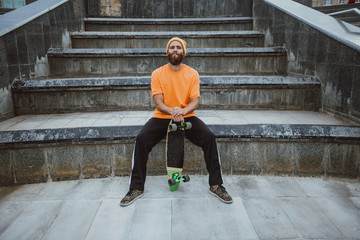 Handsome young stylish hipster guy with beard with a skateboard © San4ezz007
