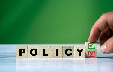 hand turns the wooden cube and changes the word POLICY