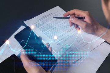 Multi exposure of man signing contract with phone and financial chart hologram. Concept of market...