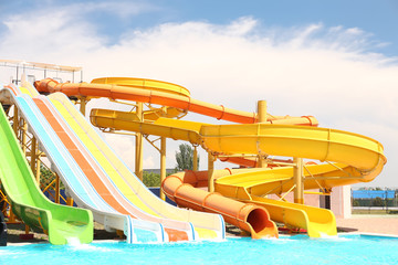 Different colorful slides in water park on sunny day