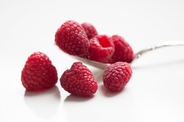 Red Raspberries in Sterling Silver Spoon on White Background