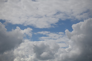 Naklejka na ściany i meble Disturbing dense clouds, dragging the blue sky