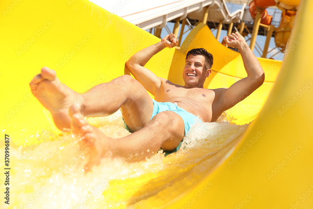 Poster Man on slide at water park. Summer vacation