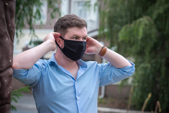 Social distance. Stop virus ! Young Man in Textile black cotton mask	
