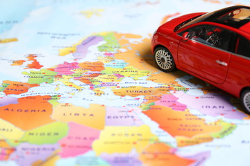 Red toy car on world map, closeup. Trip planning - Powered by Adobe
