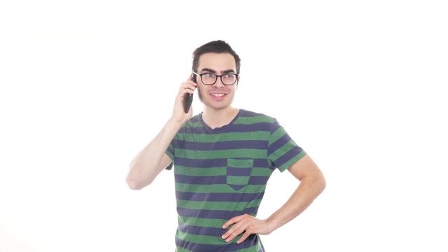 Young man talking on his phone over a white background.