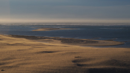 Vue sur l'océan atlantique depuis la Dune du Pilat.  L'horizon est brumeux à cause du sable brassé par le vent