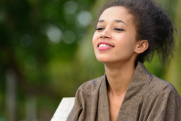 Portrait of happy young beautiful African woman at the park