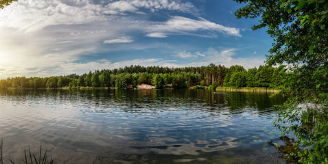 Beautiful lake in the woods with pine trees on the shore for summer vacation. Travel to Ukraine.