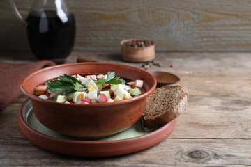 Delicious cold okroshka with kvass served on wooden table. Traditional Russian summer soup