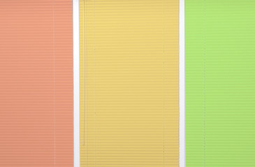 Window with closed multicolor blinds as background