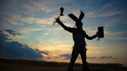 Man in image of sorcerer performs a voodoo ritual and holds doll impaled wire.