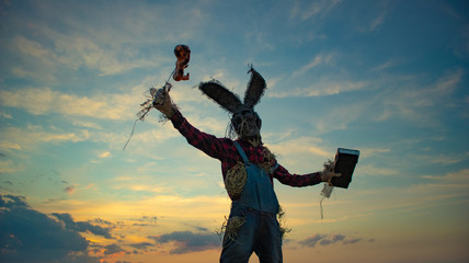 Man in image of sorcerer performs a voodoo ritual and holds doll impaled wire.