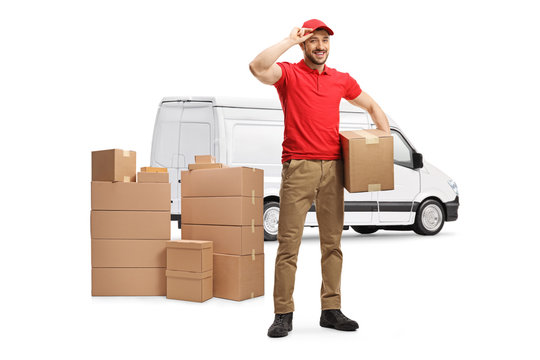Full length portrait of a delivery man with a van holding a cardboard box and greeting