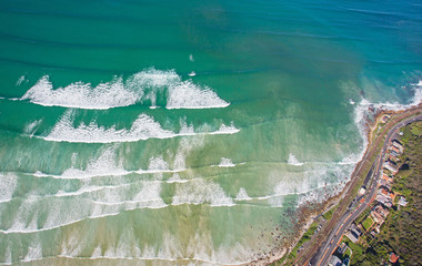 Cape Town, Western Cape / South Africa - 07/24/2020: Aerial photo of surfer and waves at Muizenberg Beach
