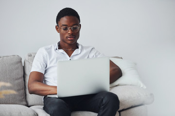 Young african american man in formal clothes indoors with laptop in hands