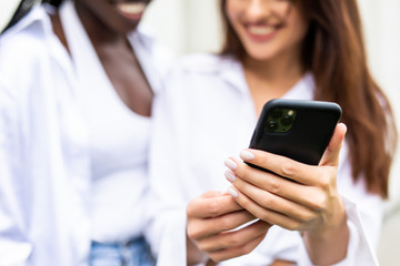 Beautiful mixed race women using a mobile in the Street. Youth concept.