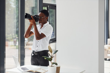 Testing camera. Young african american man in formal clothes is in the office