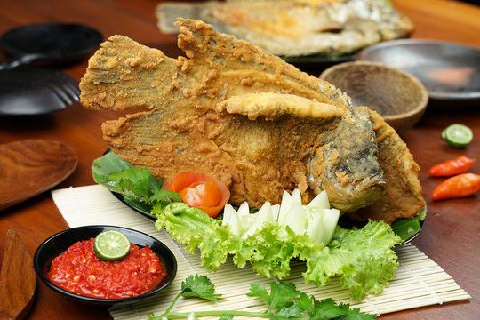 Flying fried fish with raw sambal on a wooden table. Usually used for menu list pictures or food pictures in restaurants. Top view