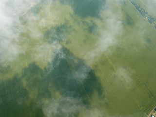 High flight in the clouds over agricultural fields.