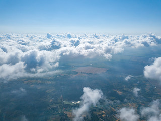 Fototapeta premium High flight in the clouds over agricultural fields.