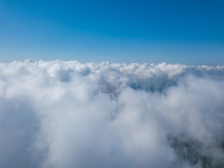 High flight in the clouds over agricultural fields.