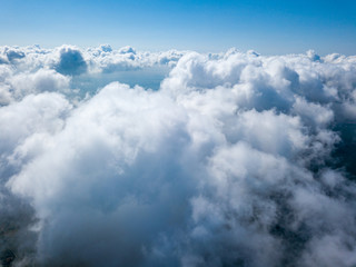 High flight in the clouds over agricultural fields.