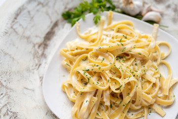 Alfredo pasta dinner with creamy white sauce and herbs