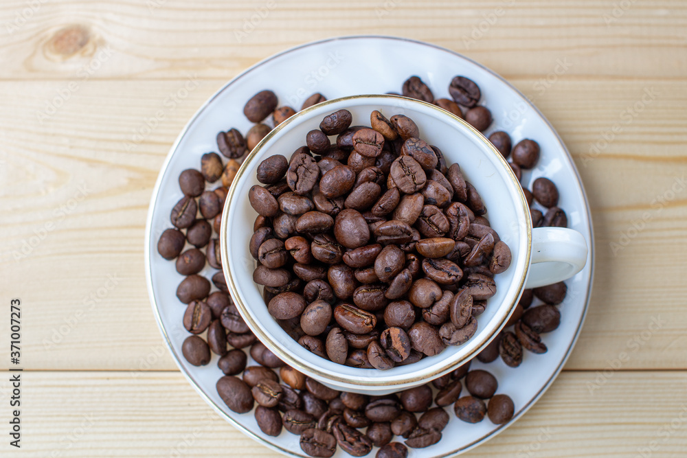 Poster white mug with cup of coffee beans on wooden background with selective focus and crop fragment