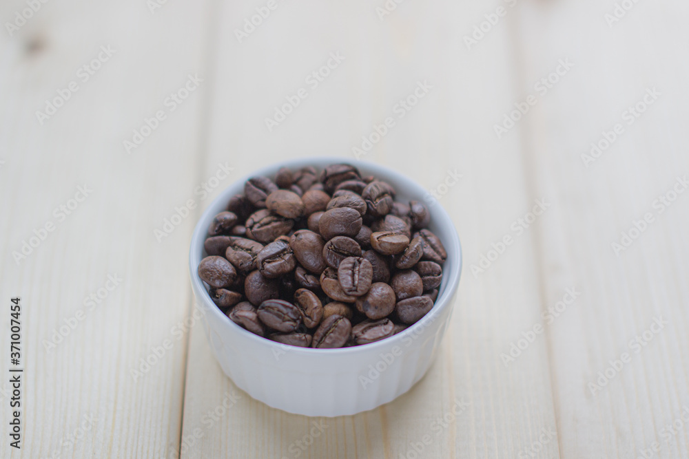 Poster white mug with cup of coffee beans on wooden background with selective focus and crop fragment
