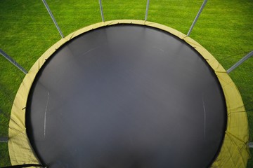 trampoline with big round mat on green lawn